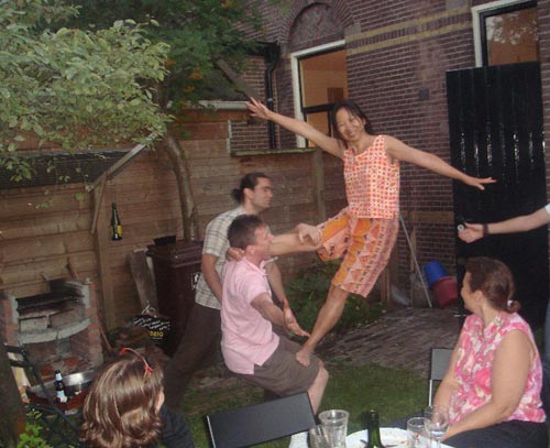 Anne balancing on Robert's knee with help of Emile and Annelies on 15 July 2010